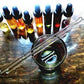 botanical perfume ingredients of essential oils and absolutes in bottles, with a vessel and stirrer to blend